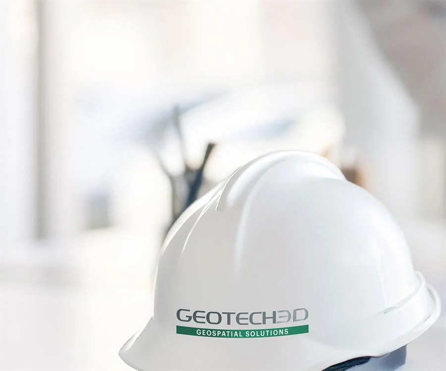 GEOTECH 3D engineering helmet beside project drawings